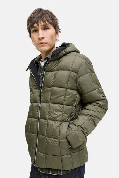 Zwarte regenjas van JACK & JONES, met capuchon en ritssluiting, over een geruit overhemd.