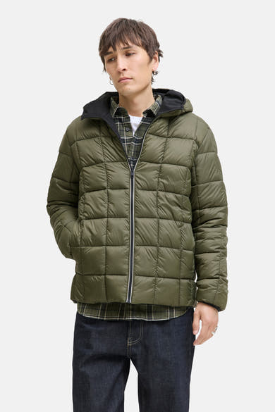 Zwarte regenjas van JACK & JONES met capuchon, gedragen over een geruit overhemd en een spijkerbroek.