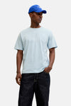 T-shirt à manches courtes bleu de JACK & JONES, porté avec un jean foncé et une casquette bleue.
