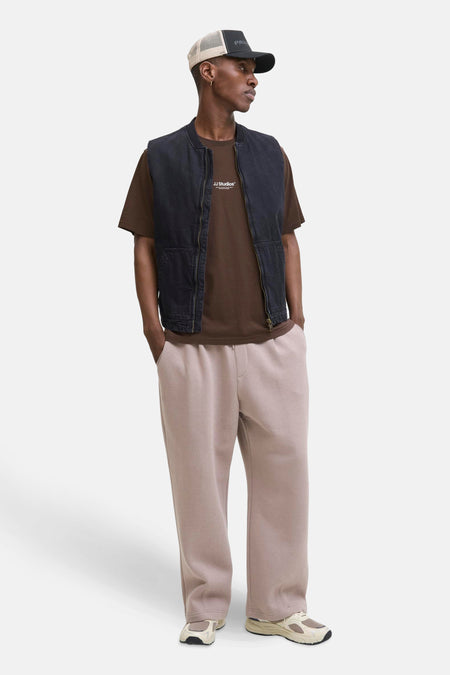 Bruin T-shirt met korte mouwen van JACK & JONES, gedragen met een zwart mouwloos vest en een roze broek.
