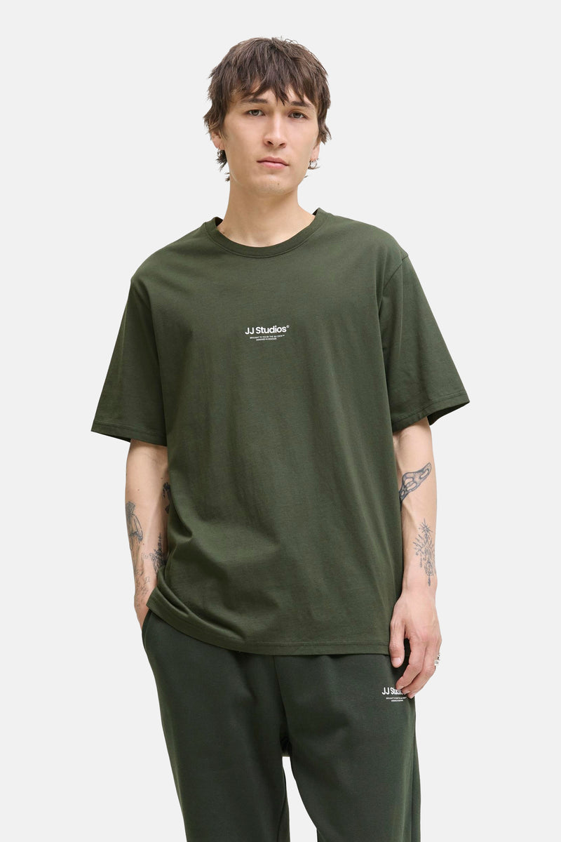 Groen T-shirt met korte mouwen van JACK & JONES, met tatoeages op de armen en een bijpassende joggingbroek.