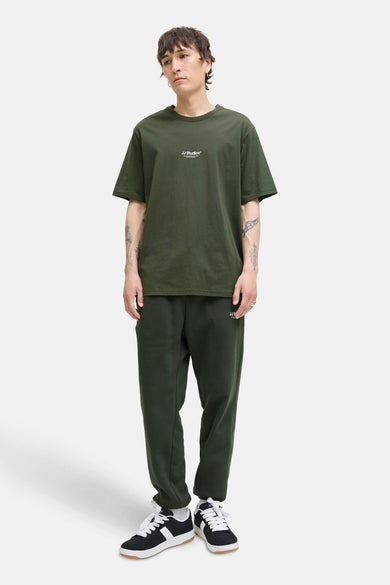 Groen T-shirt met korte mouwen van JACK & JONES, gedragen met een joggingbroek en sneakers.