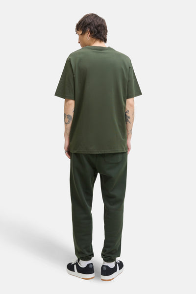 Groen T-shirt met korte mouwen van JACK & JONES, gedragen met een zwarte joggingbroek en sneakers.