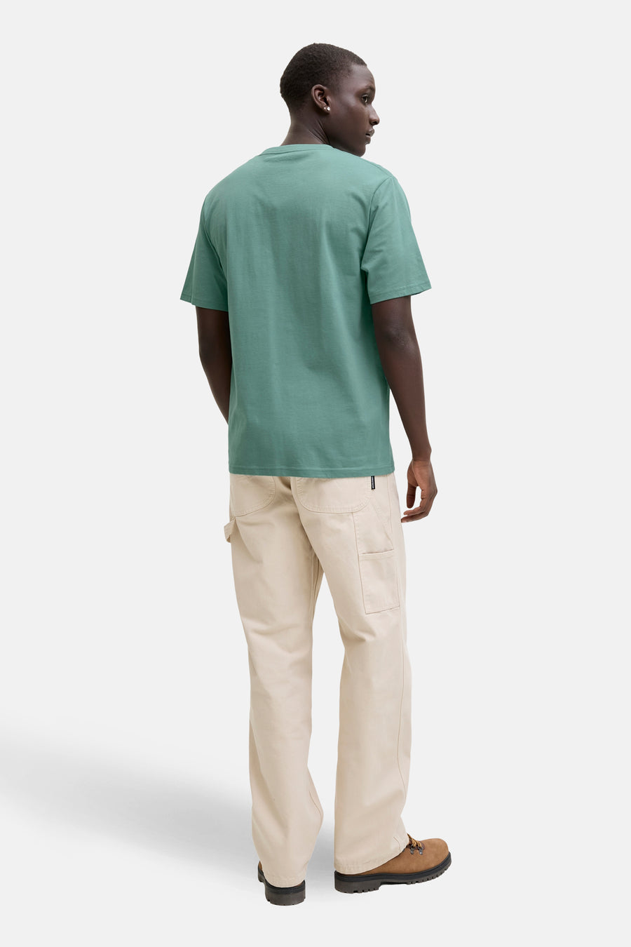 Blauw T-shirt met korte mouwen van JACK & JONES, gedragen met een beige broek en bruine wandelschoenen.