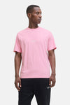 Roze T-shirt met korte mouwen van JACK & JONES, gedragen met een zwarte joggingbroek en zwart-witte sneakers.