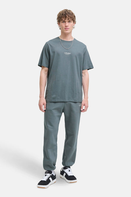 Blauw T-shirt met korte mouwen van JACK & JONES, gedragen met een joggingbroek en zwarte sneakers.