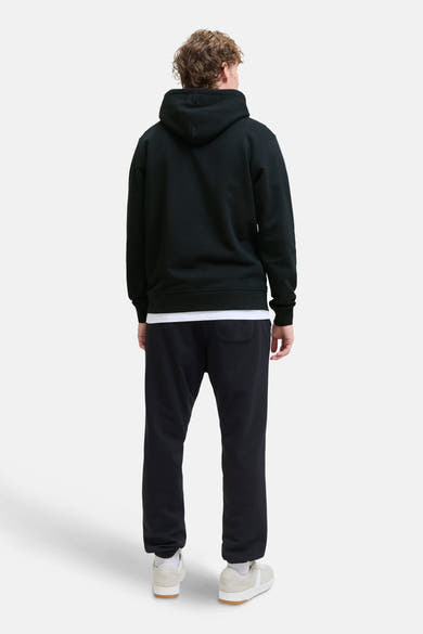 Sweat à capuche noir de JACK & JONES, porté avec un t-shirt blanc et un pantalon de survêtement noir, vue de dos.