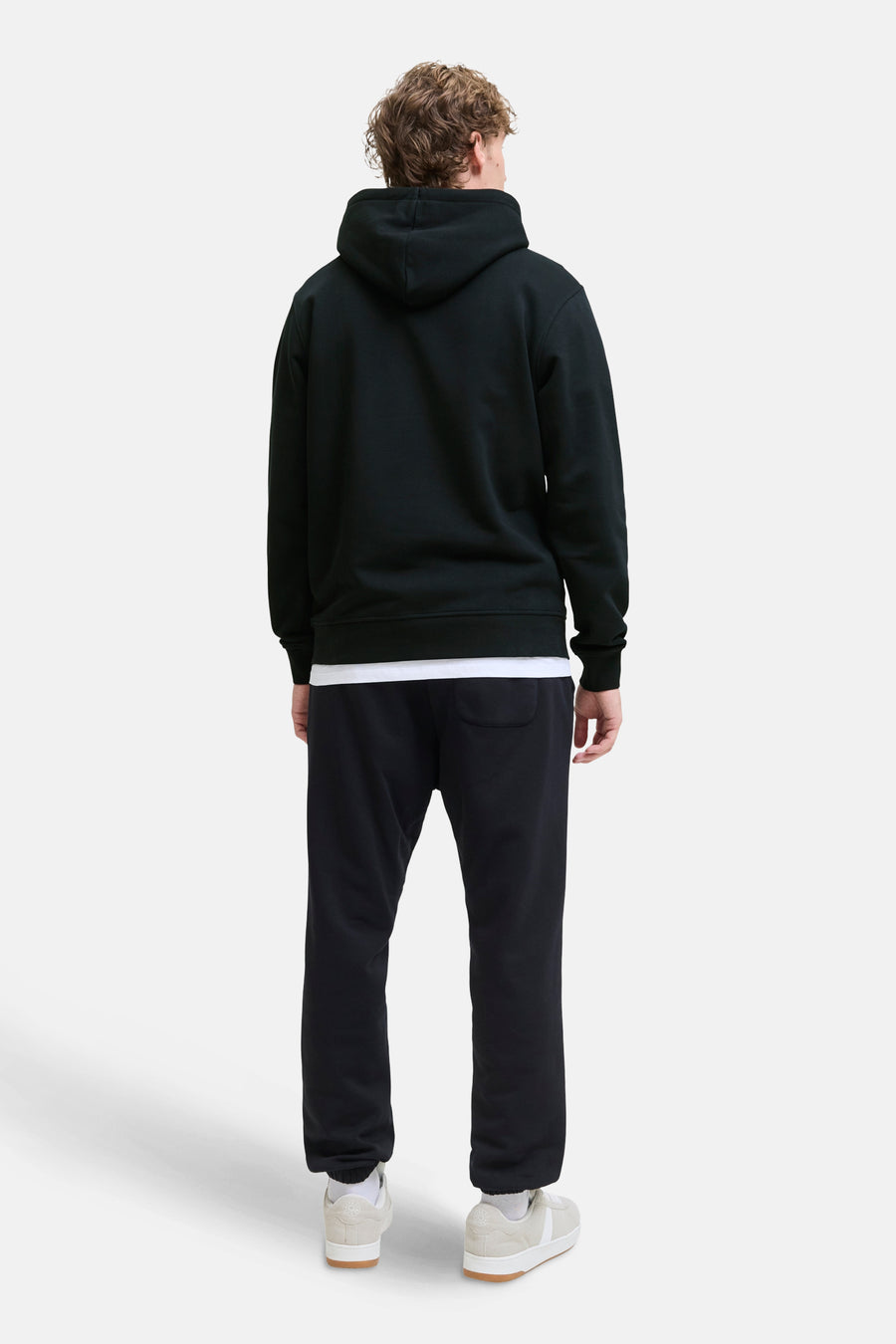 Sweat à capuche noir de JACK & JONES, porté avec un t-shirt blanc et un pantalon de survêtement noir, vue de dos.