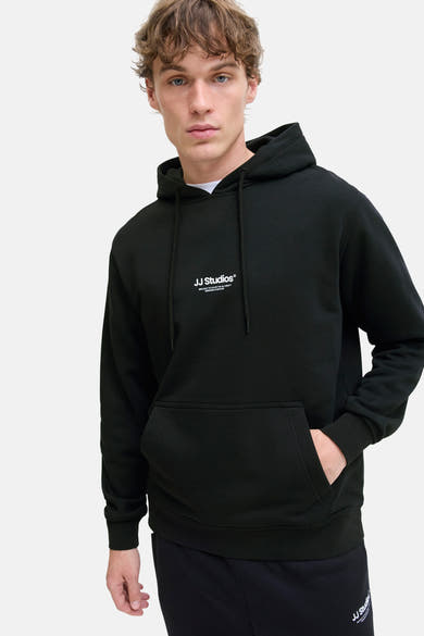 Sweat à capuche noir de JACK & JONES avec cordon de serrage et poche kangourou, porté sur un t-shirt blanc.