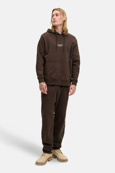 Kaki hoodie van JACK & JONES, gedragen met een bijpassende joggingbroek en beige suède schoenen.