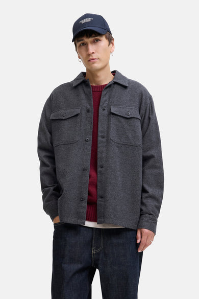 Chemise grise par PREMIUM BLUE by JACK & JONES, avec des poches à rabat, portée avec un pull bordeaux, un jean foncé et une casquette bleu marine.
