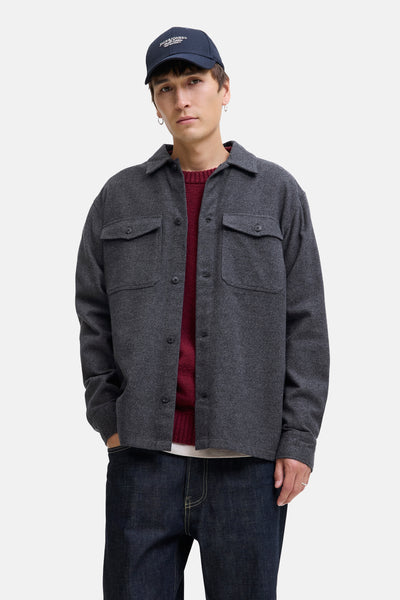 Chemise grise par PREMIUM BLUE by JACK & JONES, avec des poches à rabat, portée avec un pull bordeaux, un jean foncé et une casquette bleu marine.
