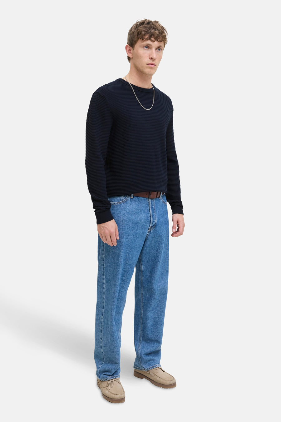 Pull bleu à col rond par JACK & JONES, porté avec un jean et des chaussures bateau.