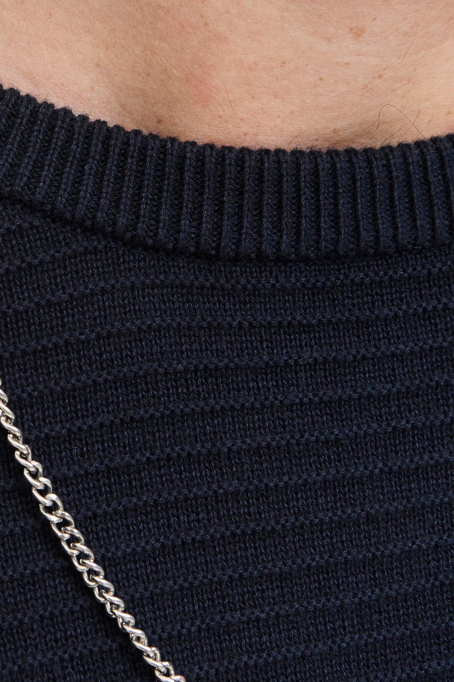 Pull à col rond bleu de JACK & JONES, avec motif texturé et chaîne décorative argentée.