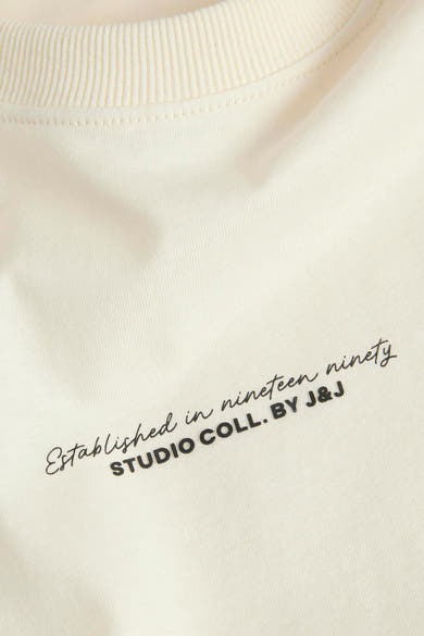T-shirt écru à manches courtes de JACK & JONES avec inscription stylisée sur le devant.