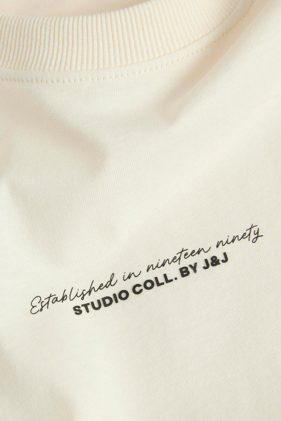 T-shirt écru à manches courtes de JACK & JONES avec inscription stylisée sur le devant.