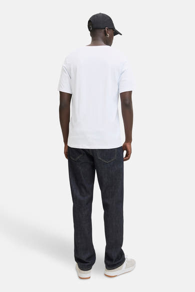 T-shirt à manches courtes blanc par ORIGINALS BY JACK & JONES, porté avec un jean bleu foncé et des baskets.