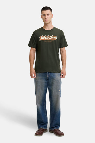 T-shirt à manches courtes vert de ORIGINALS BY JACK & JONES avec un imprimé sur le devant, porté avec un jean bleu usé.
