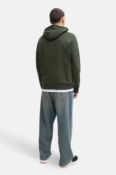 Groene hoodie van Originals by Jack & Jones, gedragen met een wit T-shirt en een wijde jeans.