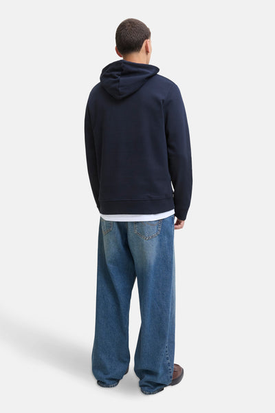 Blauwe hoodie van ORIGINALS BY JACK & JONES, gedragen met een wit T-shirt en een wijde jeans.