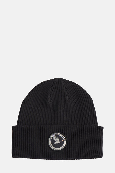 Zwarte gebreide muts van Accessories by Jack & Jones, met een rond embleem aan de voorkant.