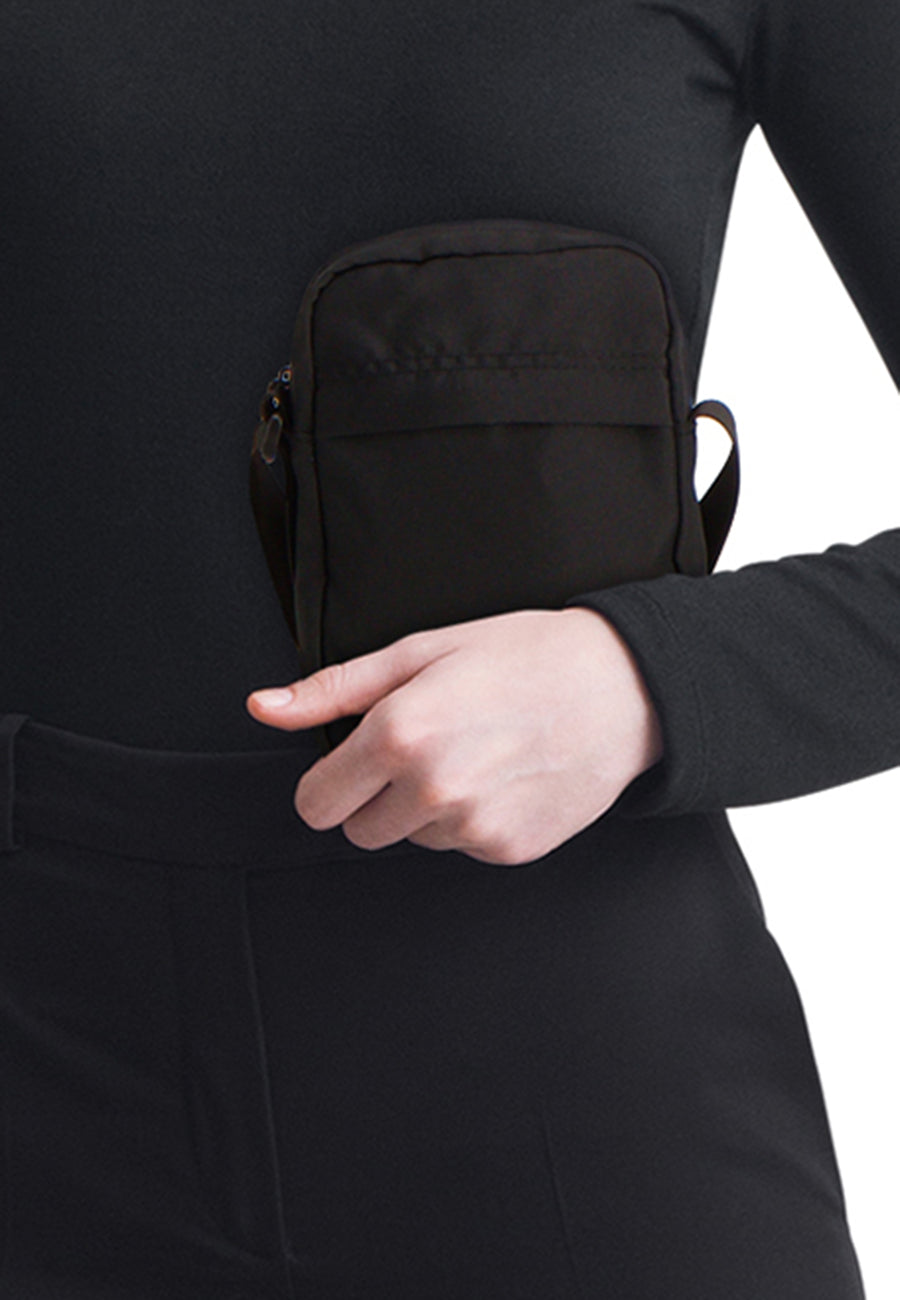Sac à bandoulière noir d'ACCESSORIES BY JACK & JONES, porté avec des vêtements noirs.