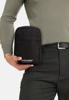 Sac à bandoulière noir ACCESSORIES BY JACK & JONES, porté avec un pantalon à carreaux et un pull vert olive.