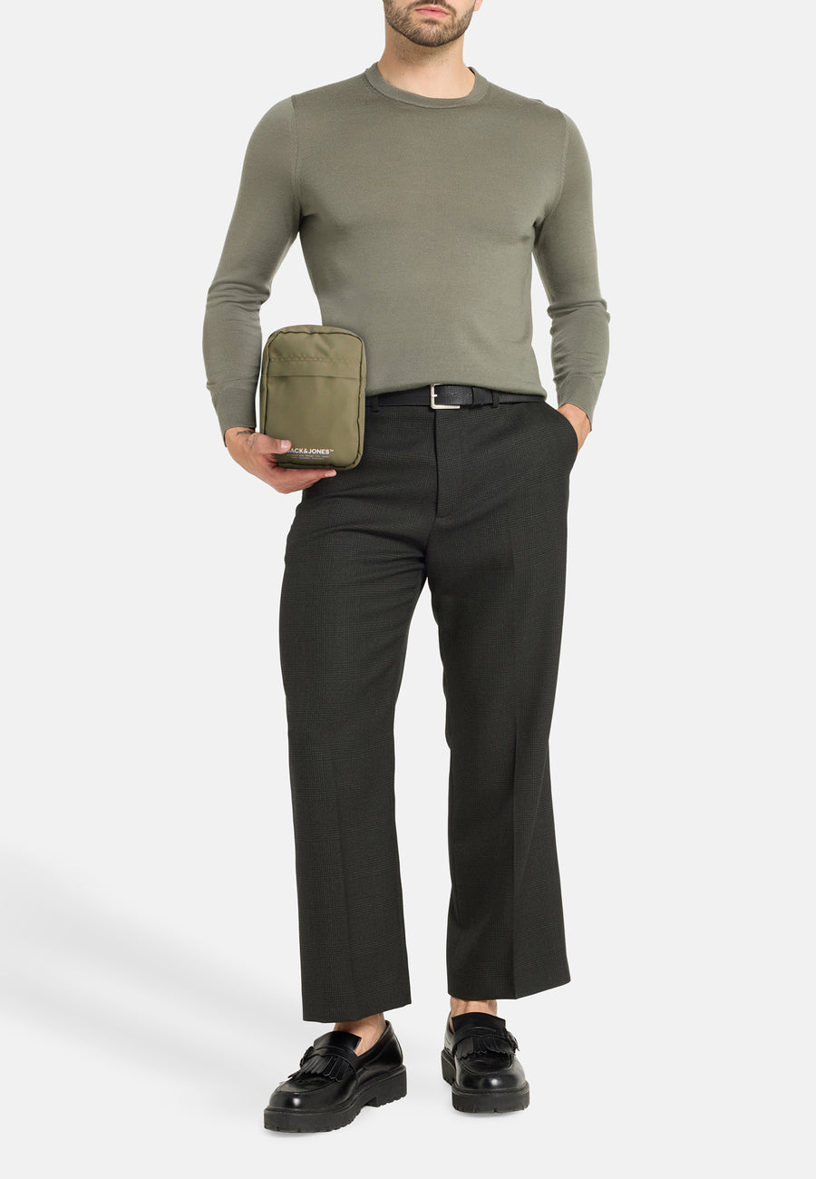 Sac à bandoulière kaki par ACCESSORIES BY JACK & JONES, porté avec un pull et un pantalon habillé.