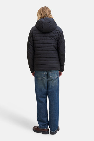 Imperméable noir de JACK & JONES, porté avec un jean ample et des chaussures marron, vue de dos.