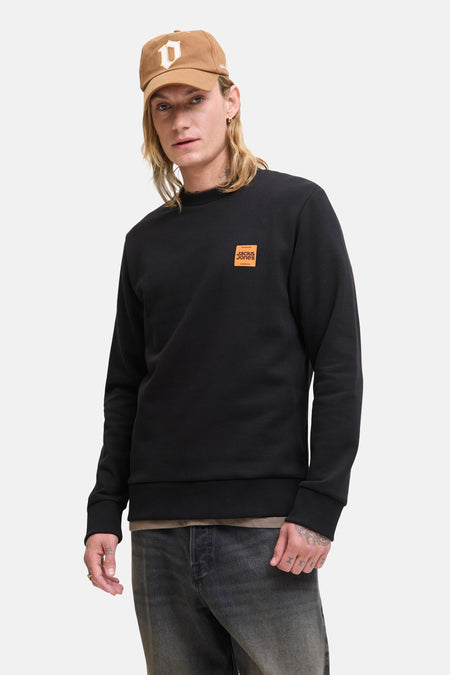 Zwarte rondehals sweatshirt van Originals by Jack & Jones, met een oranje logo-patch op de borst.