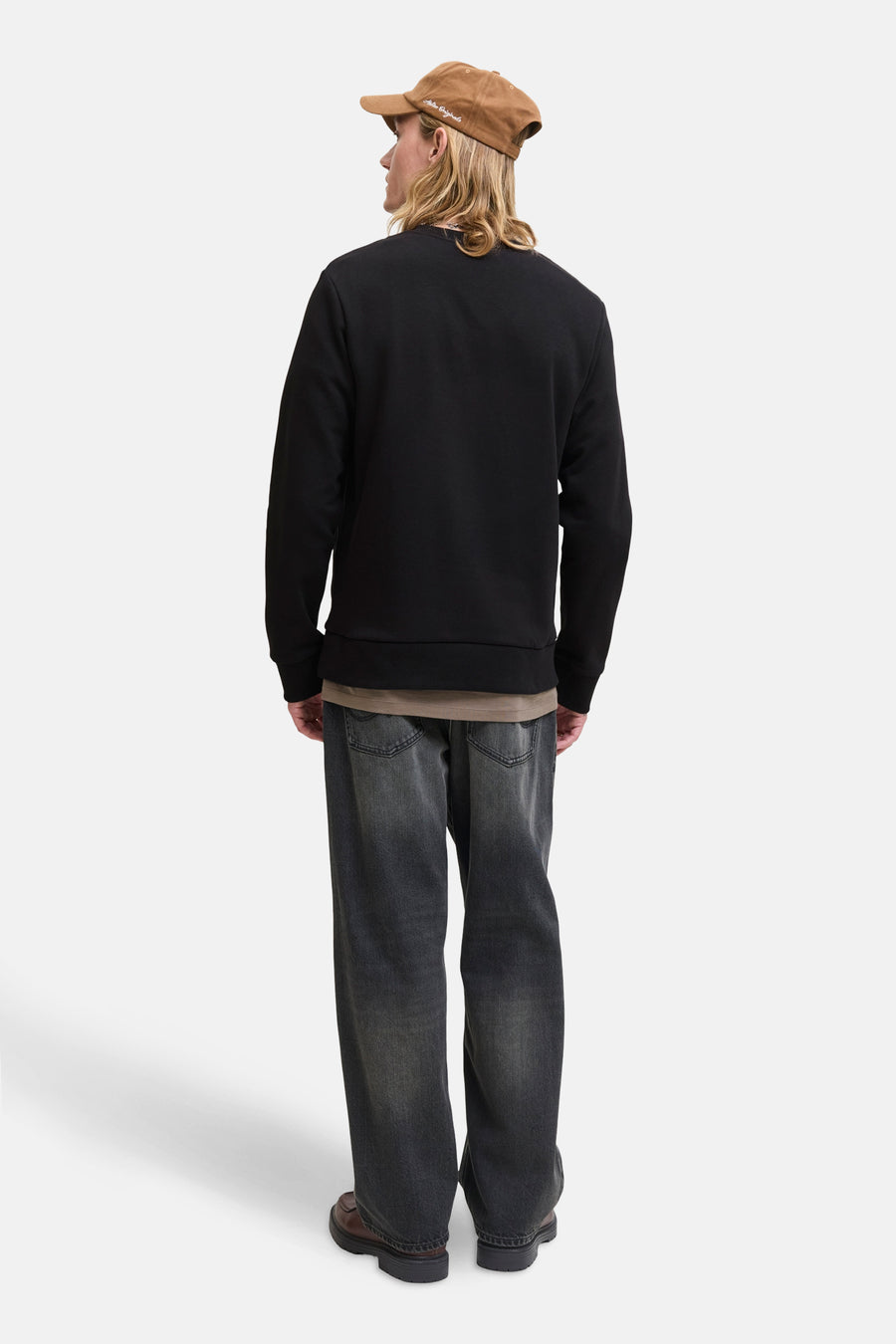 Sweat noir de ORIGINALS BY JACK & JONES, porté avec un t-shirt kaki, un jean délavé et des chaussures marron.