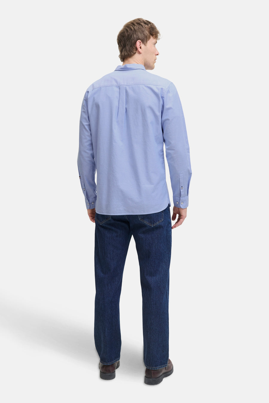 Chemise bleue à manches longues de PREMIUM by JACK & JONES, vue de dos, portée avec un jean foncé et des chaussures marron.