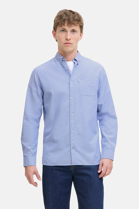 Blauw overhemd met lange mouwen van PREMIUM by JACK & JONES, gedragen met een wit T-shirt en een donkerblauwe jeans.