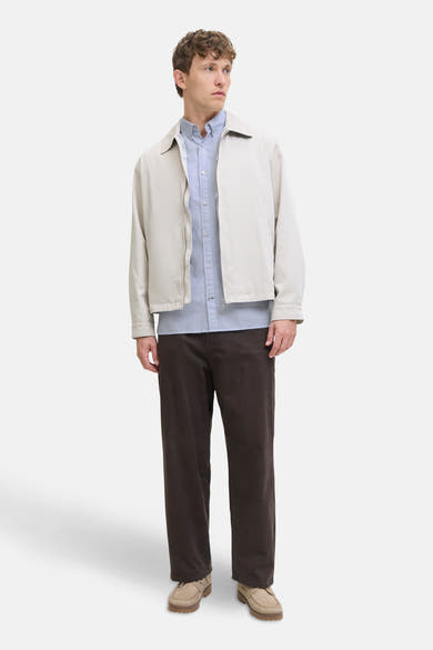 Chemise bleue à manches longues par PREMIUM by JACK & JONES, portée sous une veste beige avec un pantalon marron.