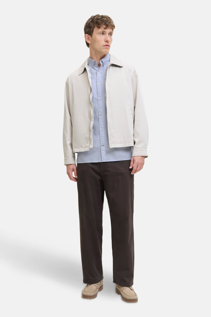 Chemise bleue à manches longues par PREMIUM by JACK & JONES, portée sous une veste beige avec un pantalon marron.