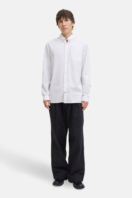 Wit overhemd met lange mouwen van PREMIUM by JACK & JONES, gedragen met een wijde zwarte broek.