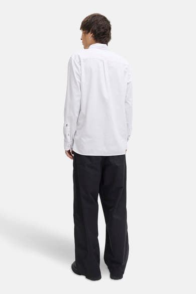 Wit overhemd met lange mouwen van PREMIUM by JACK & JONES, van achteren gezien, gedragen met een wijde zwarte broek.