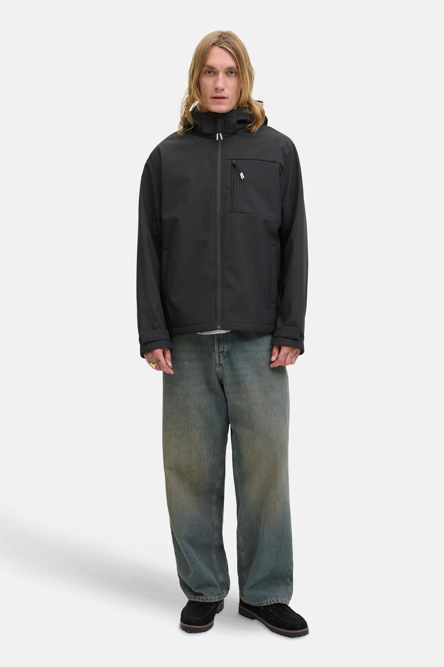 Veste courte noire de JACK & JONES, portée avec un jean ample et des chaussures bateau.