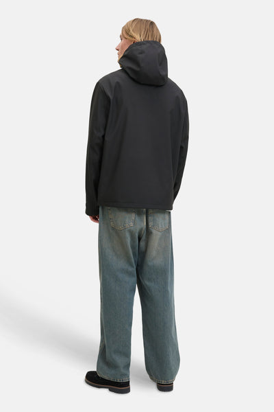 Veste courte noire par JACK & JONES, vue de dos, avec capuche et portée avec un jean ample.