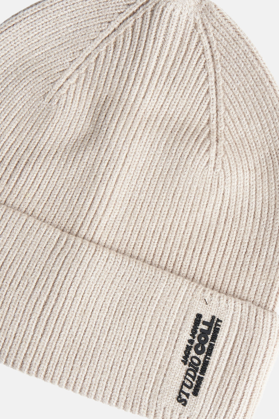 Bonnet beige en tricot de chez Jack & Jones, avec inscription "Studio Coll. Since Nineteen Ninety".
