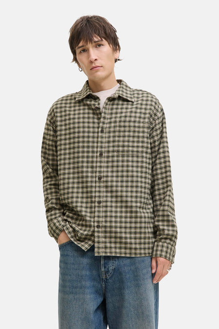 Groen geruit overhemd met lange mouwen van JACK & JONES, gedragen open over een effen T-shirt en een blauwe jeans.