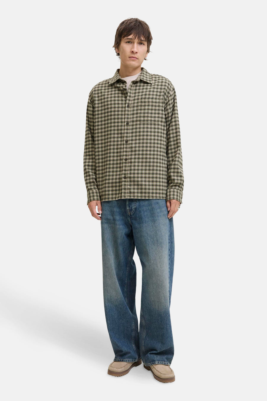 Chemise à carreaux vert par JACK & JONES, portée sur un t-shirt blanc avec un jean bleu ample.

