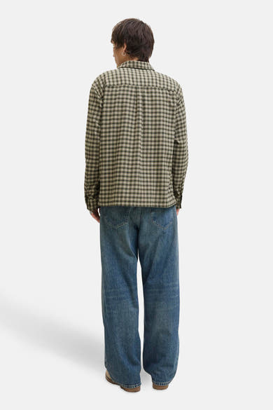 Chemise à manches longues verte à carreaux par JACK & JONES, portée avec un jean bleu ample.