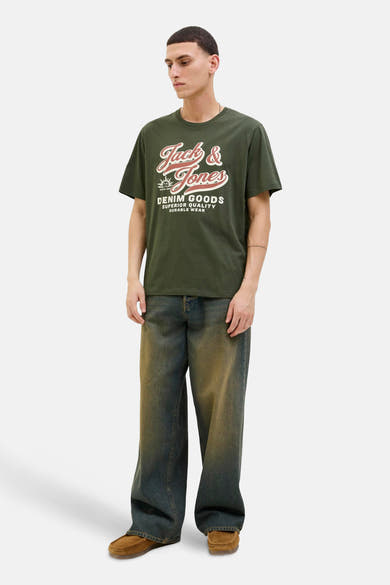 T-shirt vert à manches courtes de ORIGINALS BY JACK & JONES, avec un motif imprimé sur le devant, porté avec un jean ample et des mocassins.