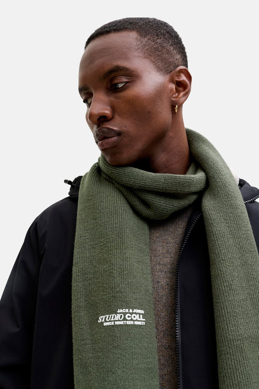 Écharpe verte en maille ACCESSORIES BY JACK & JONES, portée avec une veste noire et un pull texturé.