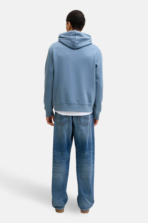Blauwe hoodie van ORIGINALS BY JACK & JONES, gedragen met een wit T-shirt en een wijde jeans.