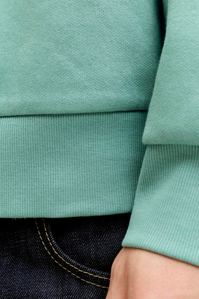 Blauwe sweater van ORIGINALS BY JACK & JONES met geribde boorden, gedragen met een zichtbare spijkerbroek.
