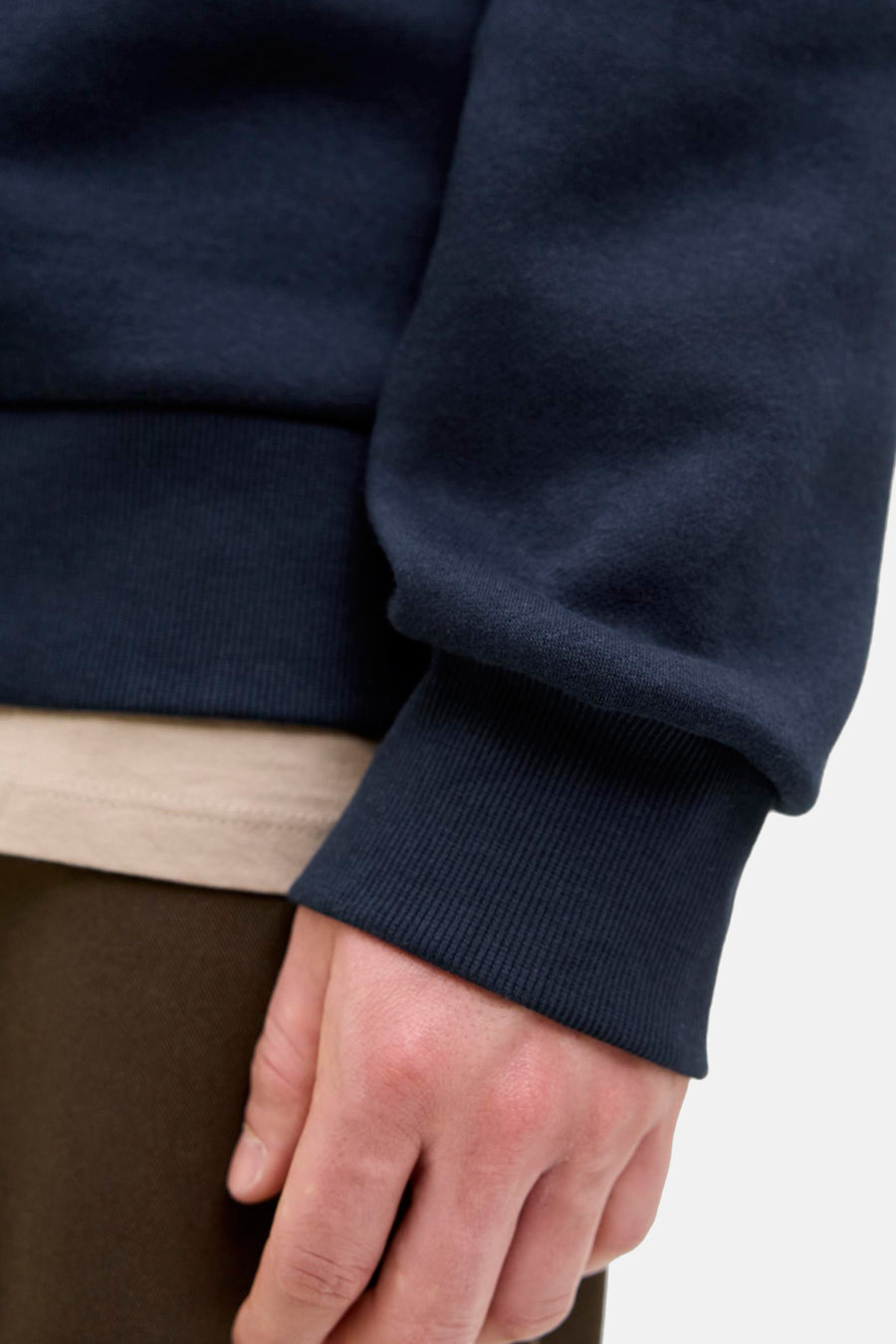 Marineblauwe hoodie van Originals by Jack & Jones, geribbelde details bij de pols, gedragen met een beige T-shirt.