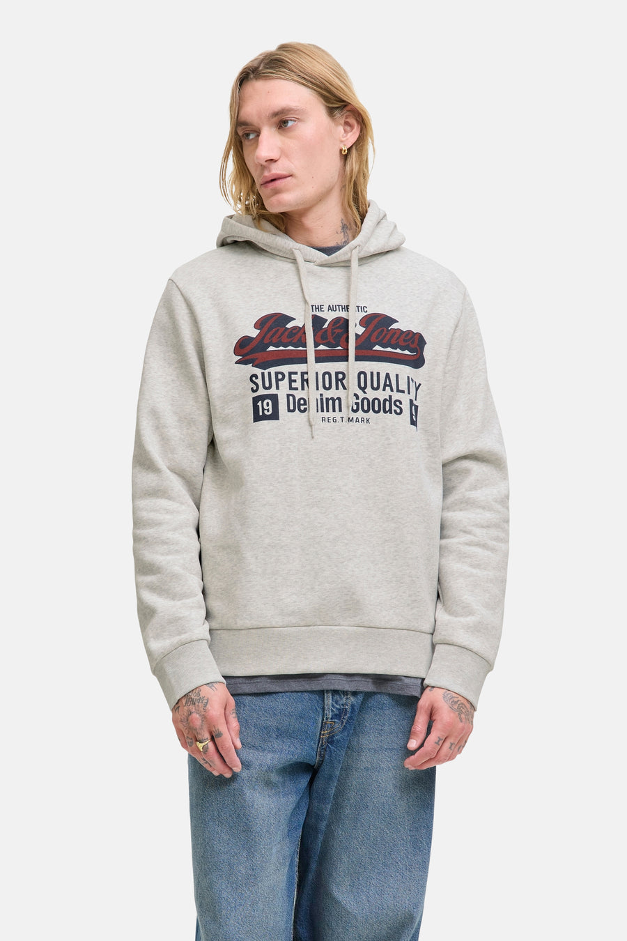 Sweat à capuche gris chiné ORIGINALS BY JACK & JONES, avec un imprimé logo sur le devant, porté avec un jean bleu.