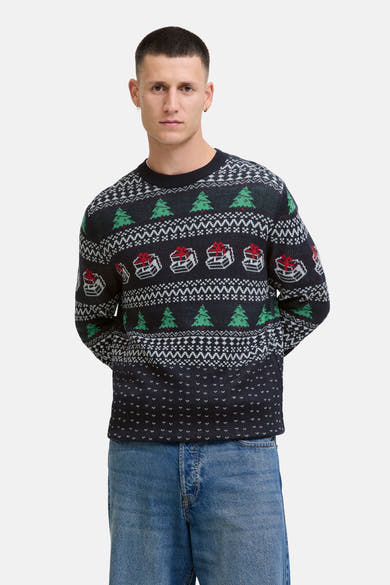 Pull à col rond bleu de JACK & JONES, avec motifs de sapins de Noël et cadeaux, porté avec un jean.
